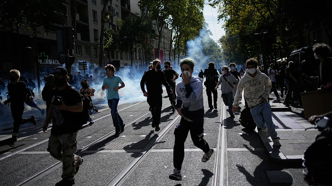 Students run out the teargas during a protest against under-resourced schools in Lyon, France, Friday, Oct. 2, 2026. (AP Photo/Laurent Cipriani)