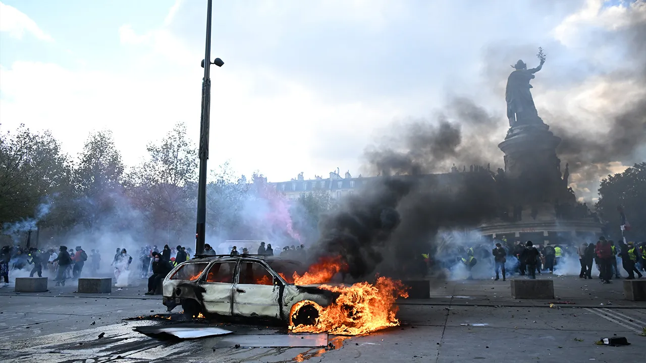 A car burns at Place de La Republique during a protest against rising living costs in Paris, Saturday, Oct. 17, 2026. (AP Photo/Emma Da Silva)