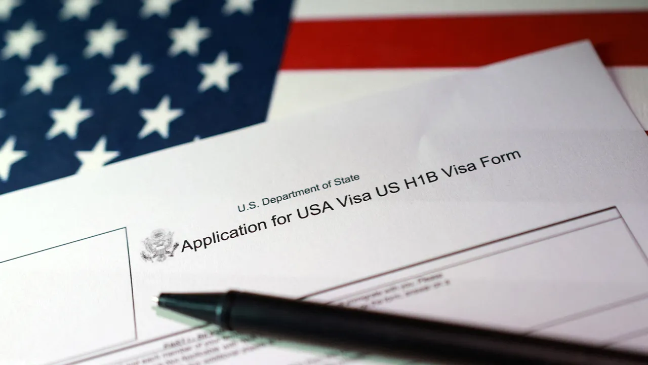 A U.S. flag and a U.S. H-1B Visa application form are seen in this illustration taken, September 22, 2025. REUTERS/Dado Ruvic/Illustration