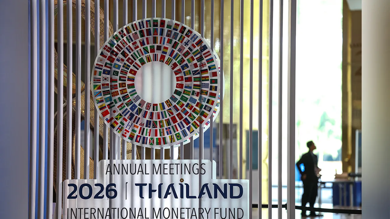 A person stands next to the logo of the 2026 IMF-World Bank Annual Meetings, ahead of the meeting at Queen Sirikit National Convention Center (QSNCC), in Bangkok, Thailand, October 9, 2026. REUTERS
