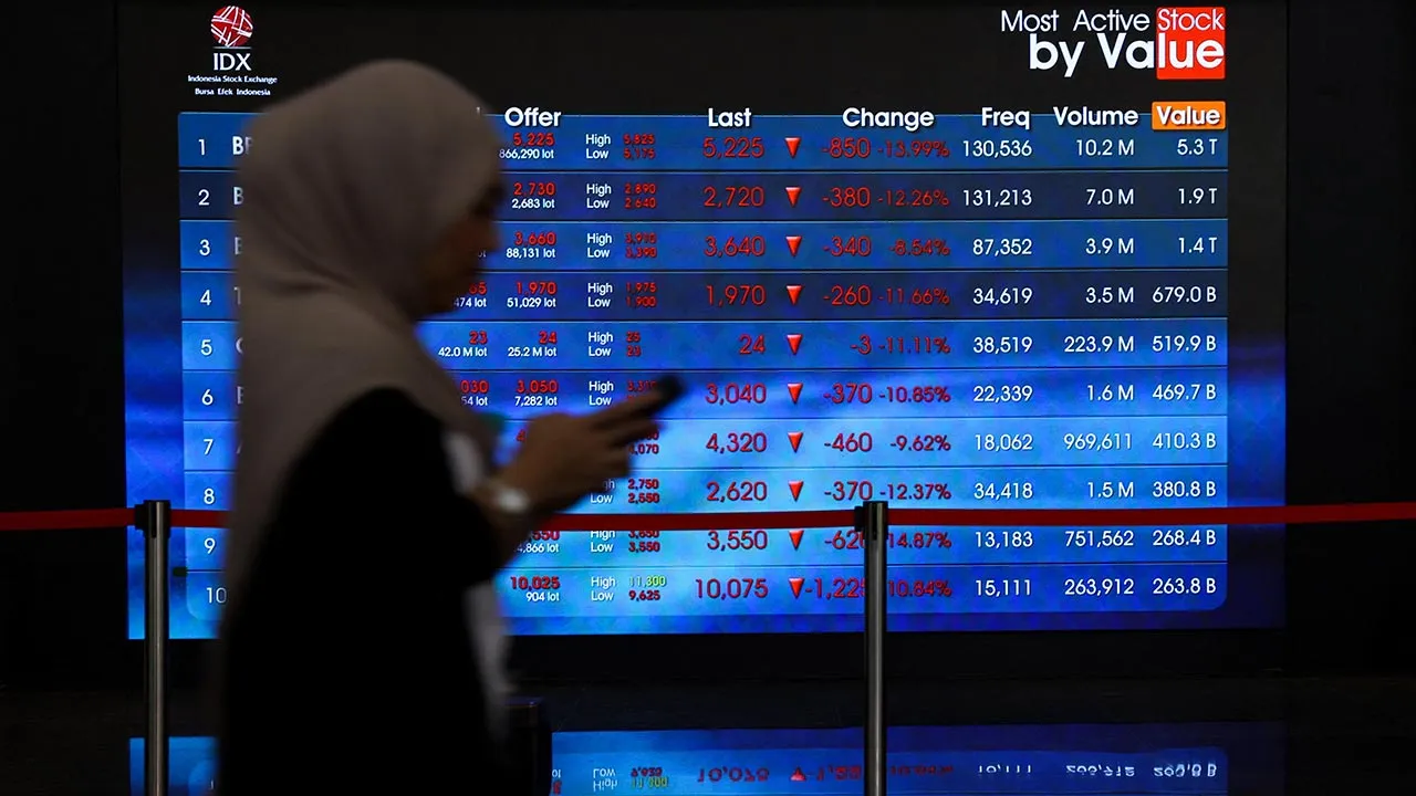 A worker walks past an electronic board displaying stock movement at the Indonesia Stock Exchange (IDX) in Jakarta, Indonesia, October 16, 2026. REUTERS/Ajeng Dinar Ulfiana