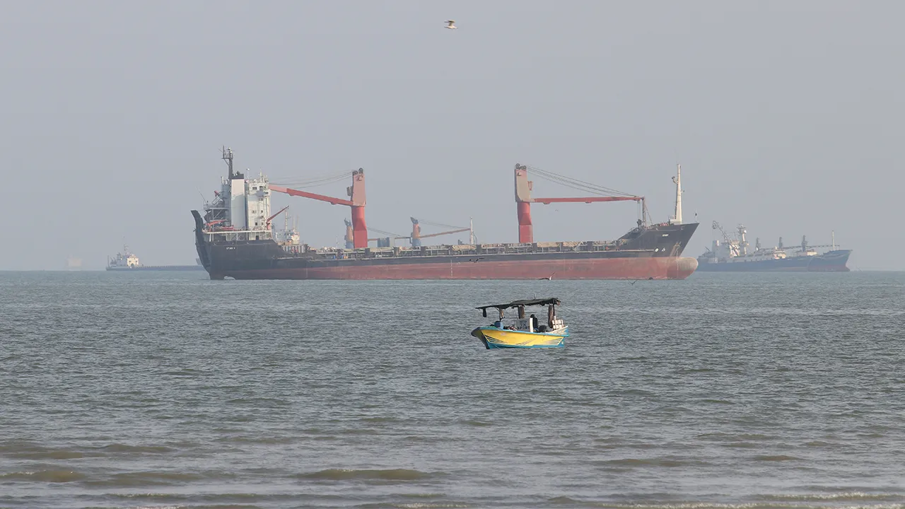 A boat floats as commercial vessels appear anchored in the Strait of Hormuz off Bandar Abbas, Iran, Tuesday, Oct. 13, 2026. (Razieh Poudat/ISNA via AP)