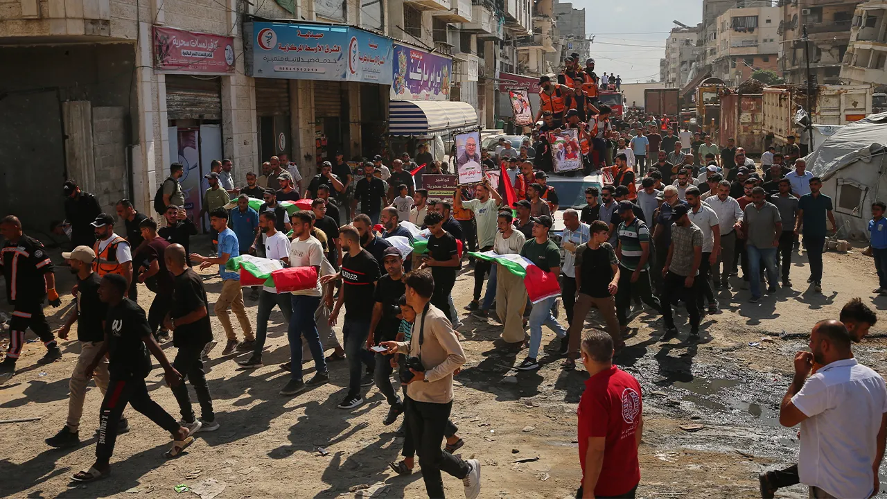 Mourners carry the flag-draped remains of Palestinians killed in Israeli strikes during the war with Hamas after they were recovered from the rubble, during their funeral in Gaza City, Thursday, Oct. 1, 2026. (AP Photo/Yousef Al Zanoun)