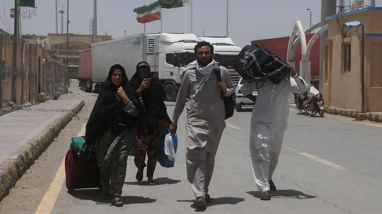 Pakistani pilgrims walk with their belongings after they returned from Iran, following the Israeli strikes in Iran, at the Pakistan-Iran border crossing in Taftan, Pakistan June 19, 2025. REUTERS/Naseer Ahmed