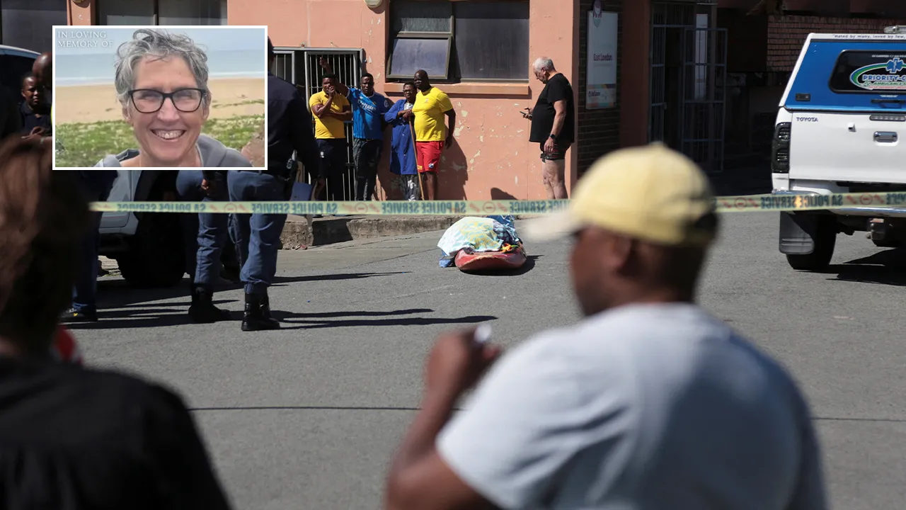 Police officers stand guard as bystanders gather near the covered body of a woman who was killed in a shark attack while swimming off Orient Beach in KuGompo City, Eastern Cape, South Africa, October 20, 2026. REUTERS/Stringer