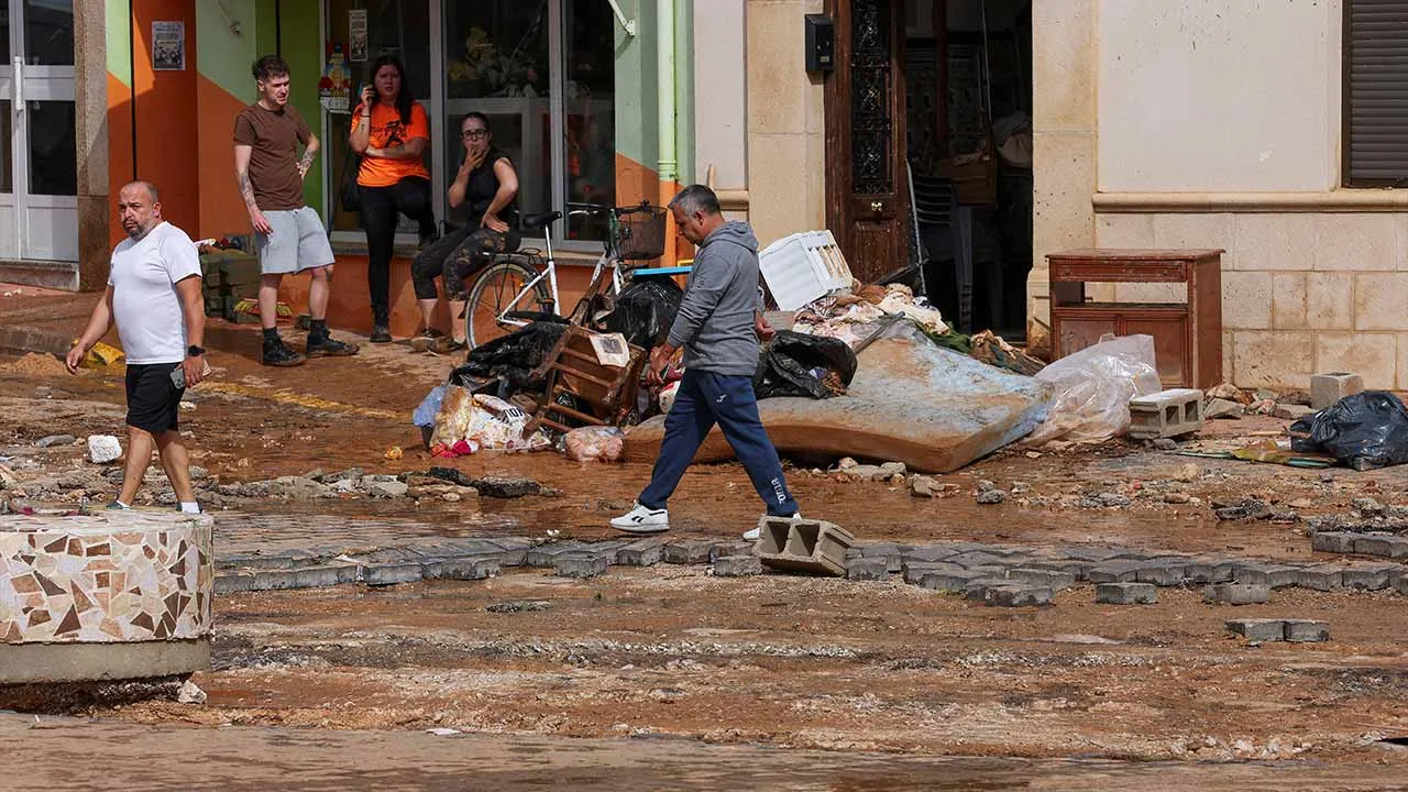 A man walks past debris in the aftermath of flooding caused by heavy rains, in Madrigueras, Spain, October 3, 2026. REUTERS/Eva Manez