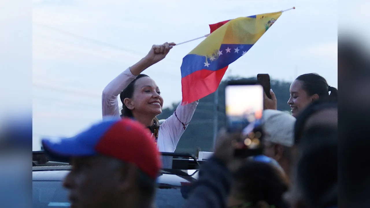 Venezuela's opposition leader Maria Corina Machado waves Venezuela's national flag after returning to the country, in Guacara, Venezuela, October 25, 2026. REUTERS/Juan Carlos Hernandez