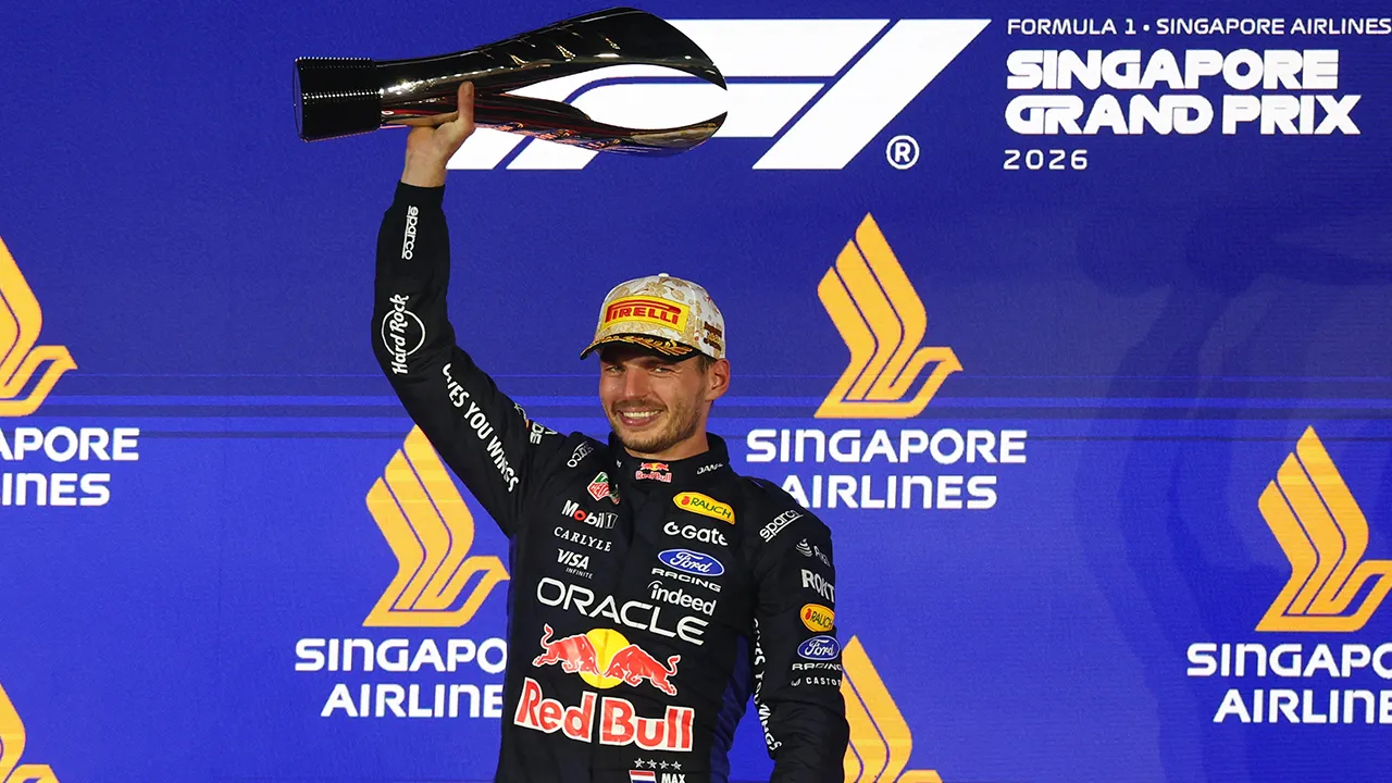 Formula One F1 - Singapore Grand Prix - Marina Bay Street Circuit, Singapore - October 11, 2026 Red Bull's Max Verstappen celebrates with a trophy on the podium after winning the Singapore Grand Prix REUTERS