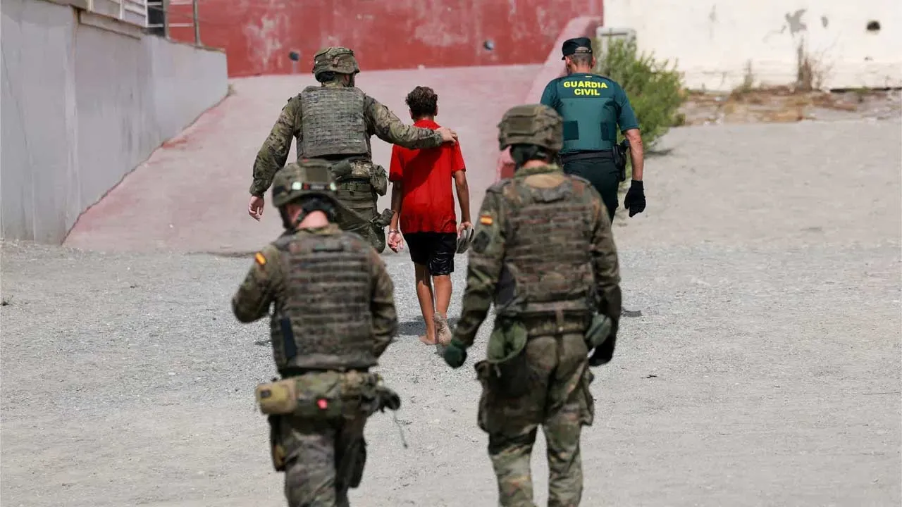 A migrant minor from Morocco is escorted by Spanish security forces after attempting to cross into Ceuta by sea amid recent mass crossings of migrants on foot and by sea from Morocco into Spanish territory, in Ceuta, Spain, August 1, 2026. REUTERS/Violeta Santos Moura