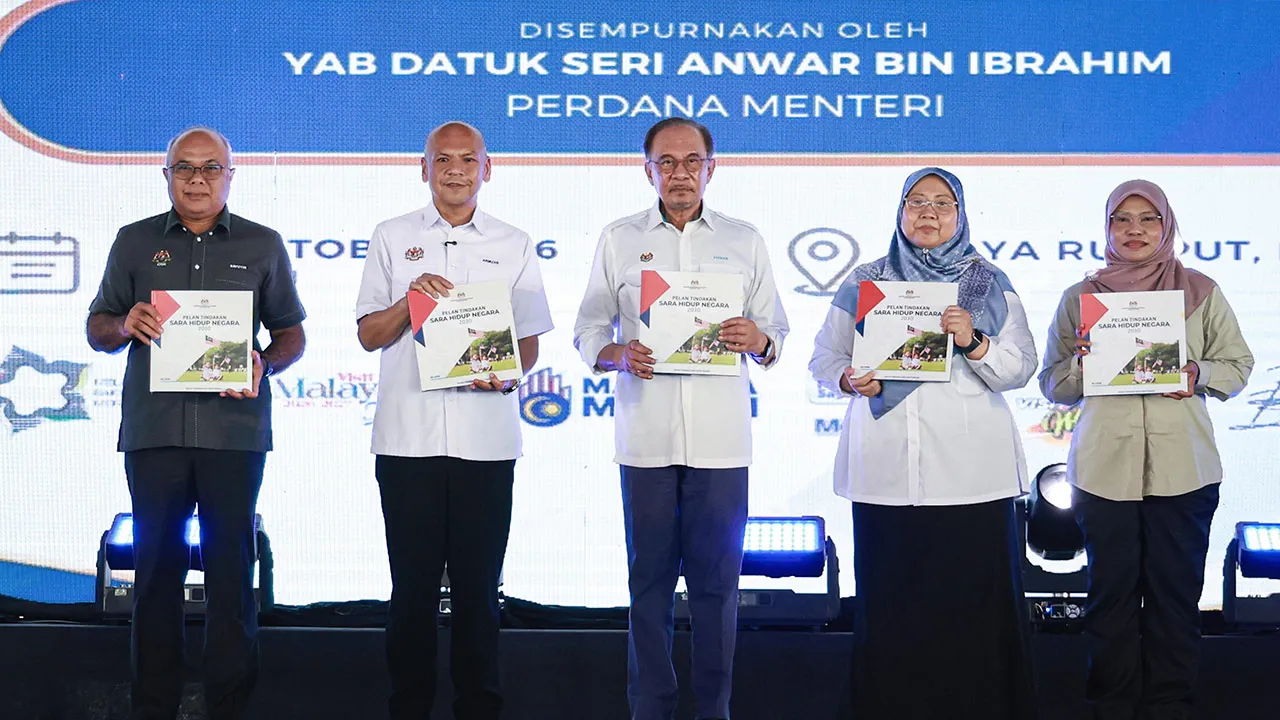 Perdana Menteri, Datuk Seri Anwar Ibrahim menunjukkan buku Pelan Tindakan Sara Hidup Negara 2030 (NCLAP2030) di Stadium Hang Jebat hari ini. fotoBERNAMA