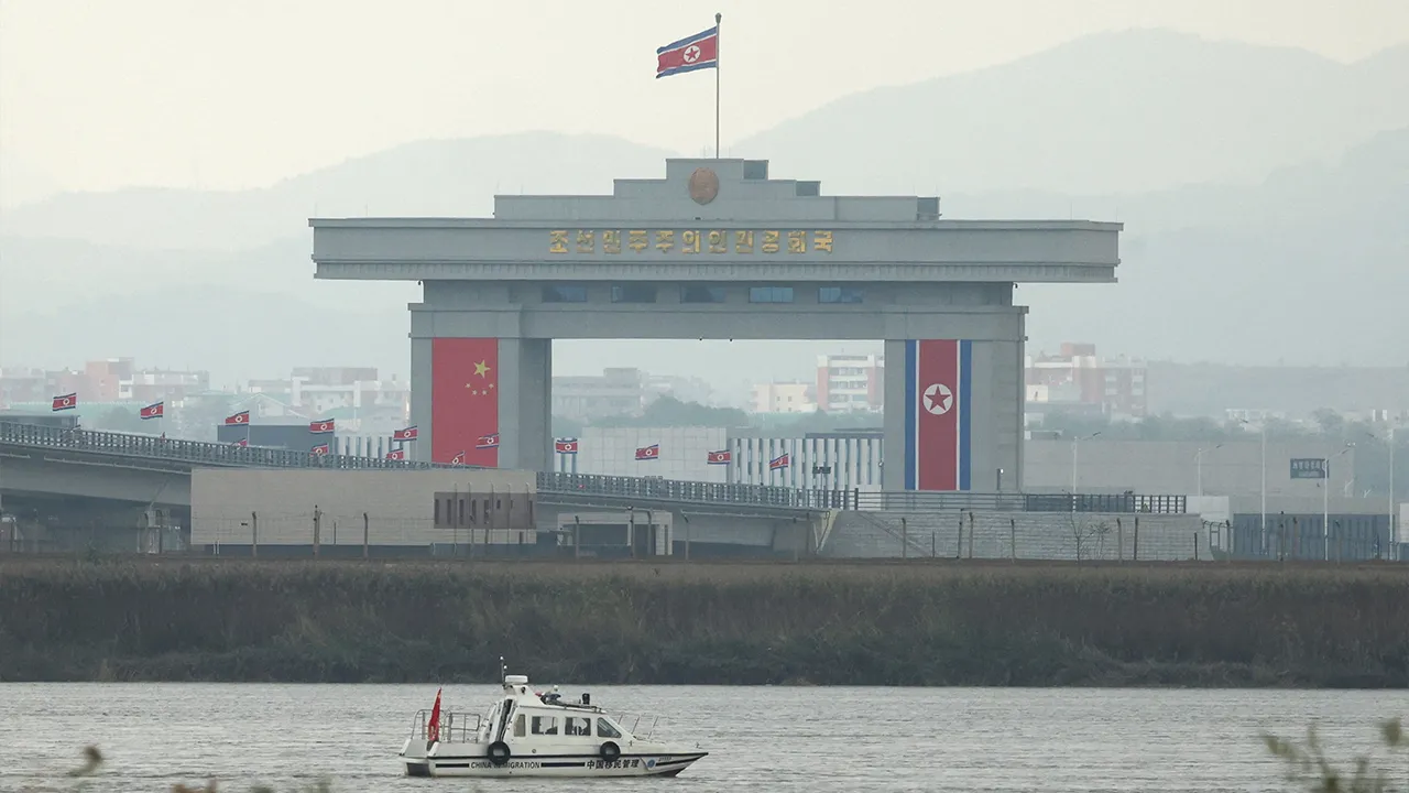 A China Immigration inspection vessel travels along the Yalu river past a North Korean customs building at the end of the newly opened New Yalu River Bridge, which connects North Korea's Sinuiju from China's Dandong New Zone, as seen from Dandong, Liaoning province, China October 15, 2026. REUTERS'