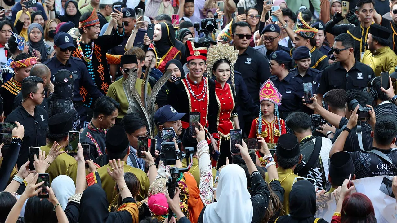 KOTA KINABALU, 31 Okt -- Ahli Parlimen Muar Syed Saddiq Syed Abdul Rahman bersama isterinya, Bella Astillah, tampil anggun mengenakan busana tradisional suku kaum Kedayan Sabah sambil melambaikan tangan kepada orang ramai pada majlis Kenduri Rakyat sempena perkahwinan mereka di Padang Bandaraya Kota Kinabalu hari ini.  Kira-kira 20,000 tetamu dari seluruh Sabah, Wilayah Persekutuan Labuan dan Brunei memeriahkan majlis berkenaan.  --fotoBERNAMA (2026) HAK CIPTA TERPELIHARA.  KOTA KINABALU, Oct 31 -- Muar Mem