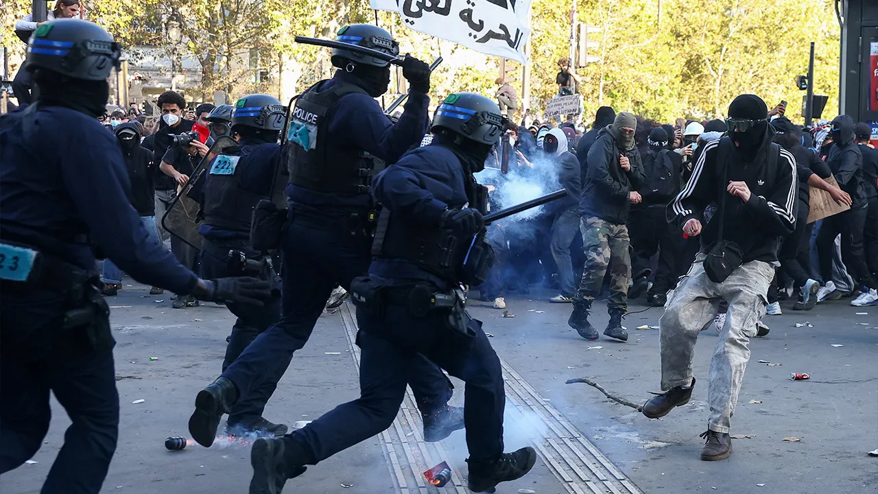 Police officers in riot gear run towards a demonstrator amid clashes during nationwide protests in Paris, France, October 8, 2026, to demand better school conditions. REUTERS/Pedro Nunes
