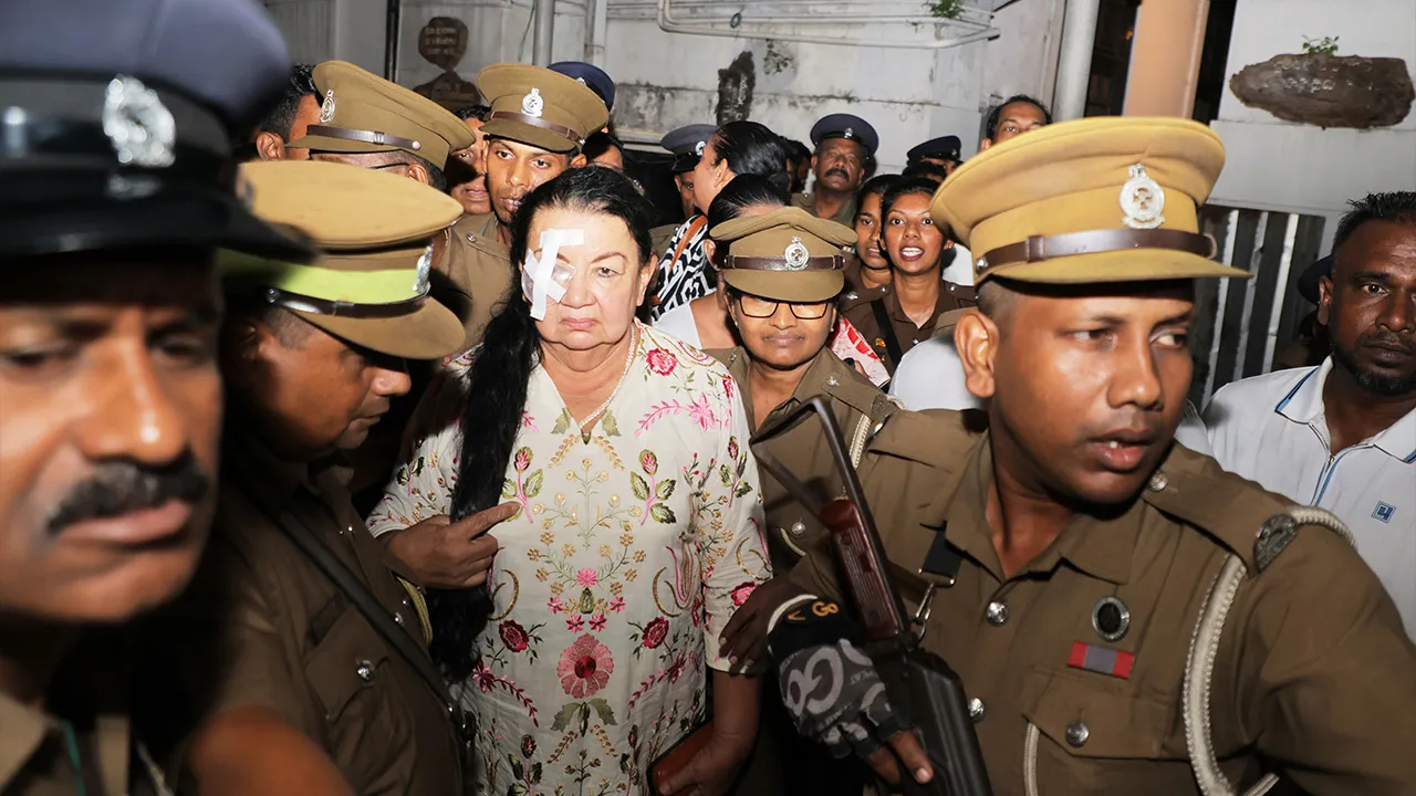 Prison officers escort Shiranthi Rajapaksa, the wife of Sri Lanka's former President Mahinda Rajapaksa, to a prison vehicle outside a magistrate's court in Colombo, Sri Lanka, Wednesday, Oct. 7, 2026. (AP Photo/Lahiru Harshana)