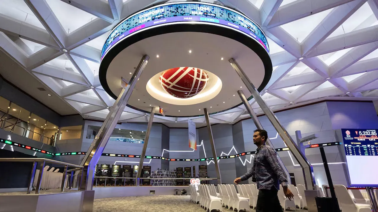 A man walks past electronic boards showing the stock market index inside a room at the Indonesia Stock Exchange (IDX) in Jakarta, Indonesia, October 21, 2026. REUTERS/Willy Kurniawan