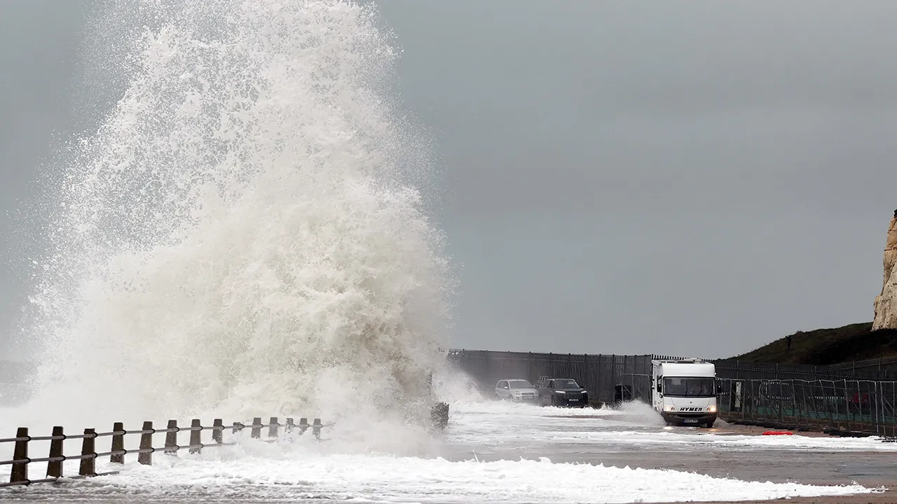 Waves crash over the sea wall as vehicles move on the road during Storm Austen in Newhaven, Britain, October 23, 2026. REUTERS/Toby Melville