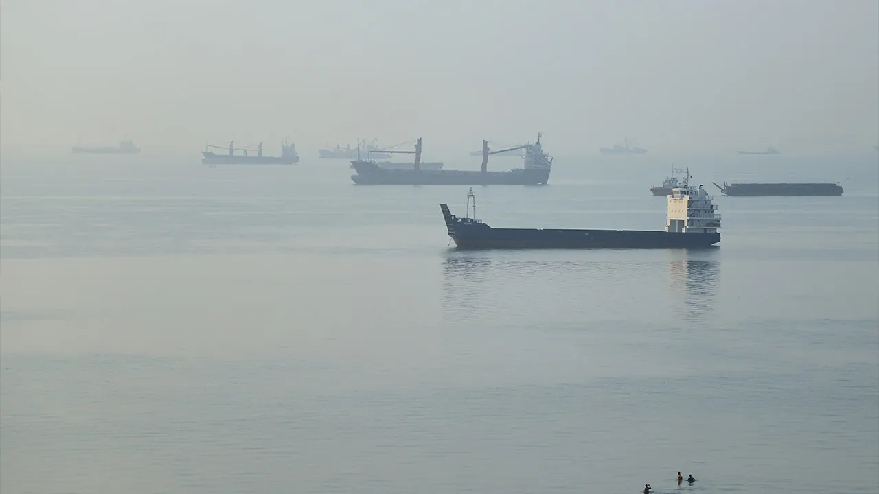 People wade in the water as cargo ships are anchored in the Strait of Hormuz off Bandar Abbas, Iran, early Monday, Sept. 28, 2026. (Amirhosein Khorgooi/ISNA via AP)