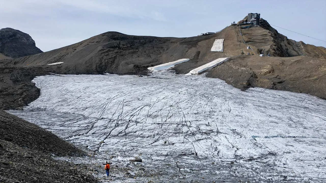 A drone view shows glaciologist at ETH Zurich and head of Glacier Monitoring in Switzerland (GLAMOS) Matthias Huss walking on the Scex Rouge glacier for his ice loss measurements amid climate change at Glacier 3000 in Les Diablerets, Switzerland, September 24, 2026. REUTERS/Denis Balibouse