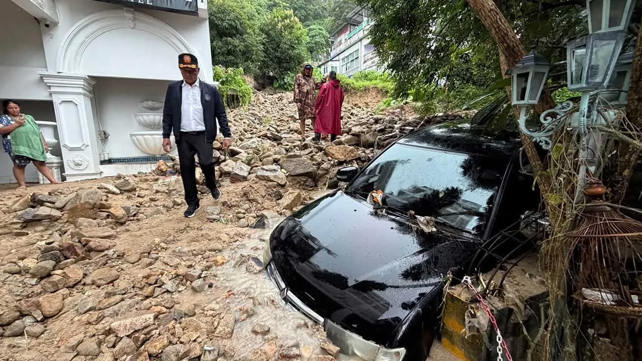 In this image from a video released by Phuket province's Public Relations Department, an official walks at the site of a mudslide after flash flooding in Phuket, Thailand, Monday, Oct. 26, 2026. (Phuket province's Public Relations Department via AP)