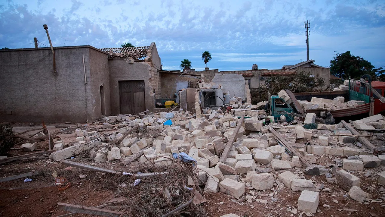 A damaged car lies amid the rubble of a partially collapsed building after a tornado struck Marsala, Sicily, Italy, October 9, 2026. REUTERS/Antonio Cascio