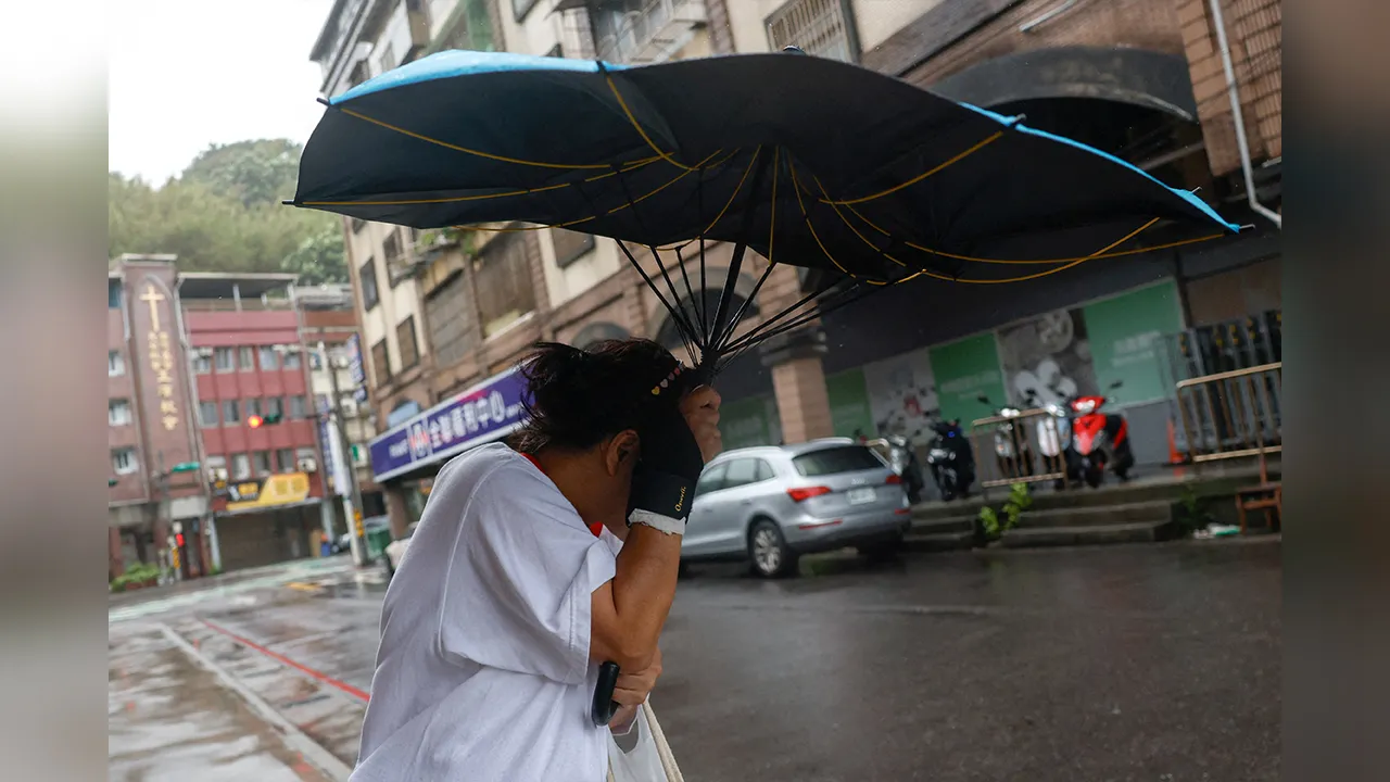 A pedestrian holds an umbrella as Typhoon Champi approaches Taiwan, in Keelung, Taiwan, October 23, 2026. REUTERS/Ann Wang TPX IMAGES OF THE DAY