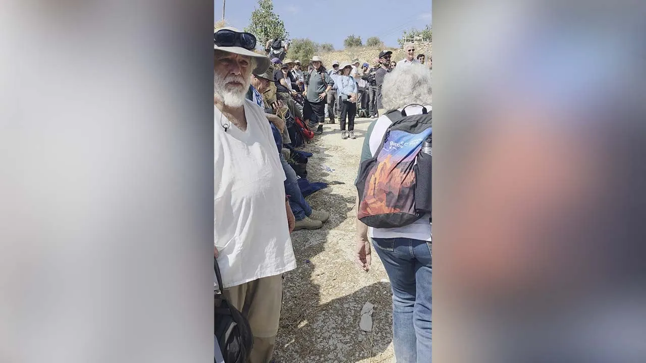 Volunteers with Rabbis for Human Rights, accompanying Palestinian farmers in the West Bank olive harvest, stand as they wait to be moved inside a bus as they are detained by the Israeli military, near Bethlehem, in the Israeli-occupied West Bank, October 21, 2026, in this frame obtained from a video. Amira Musallam/via REUTERS. THIS IMAGE HAS BEEN SUPPLIED BY A THIRD PARTY. MANDATORY CREDIT. VERIFICATION: Reuters verified the location of the videos from the road layout, trees, buildings, utility poles and m
