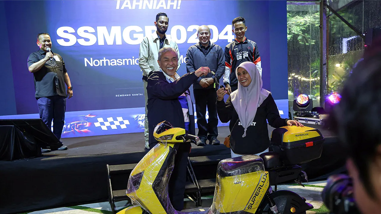 BANGI, 29 Okt -- Timbalan Perdana Menteri Datuk Seri Dr Ahmad Zahid Hamidi menyerahkan kunci kepada pemenang cabutan bertuah, Norhasmida Md Said yang memenangi sebuah motosikal pada program Sembang Santai MotoGP di Fifty Seven Coffee, Semenyih hari ini._BERNAMA