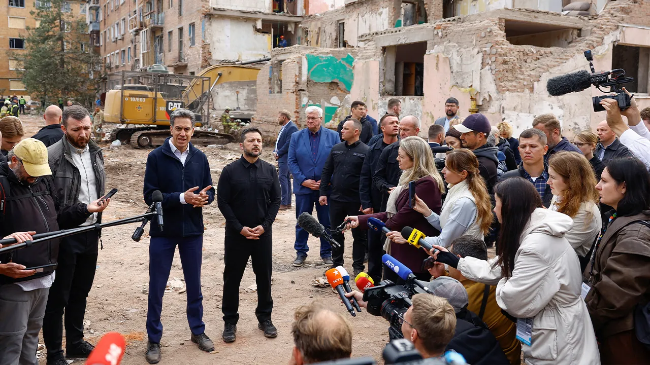 British Foreign Secretary Ed Miliband and Ukraine's President Volodymyr Zelenskiy speak to the media while they visit the site of an apartment building where 22 residents were killed yesterday morning by a Russian missile strike in the town of Pryluky, amid Russia's attack on Ukraine, in the Chernihiv region, Ukraine, October 8, 2026. REUTERS/Valentyn Ogirenko