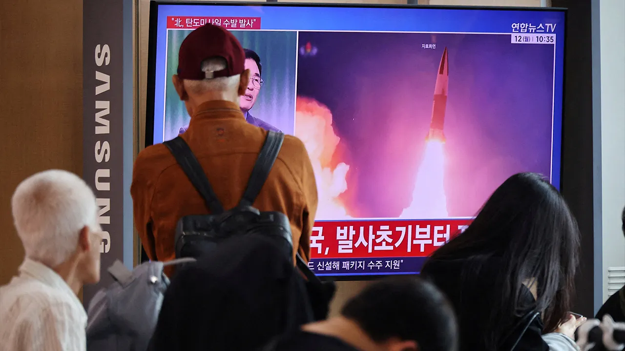 People watch a TV broadcasting a news report on North Korea firing multiple ballistic missiles toward the sea off its east coast, at a railway station in Seoul, South Korea, October 12, 2026. REUTERS