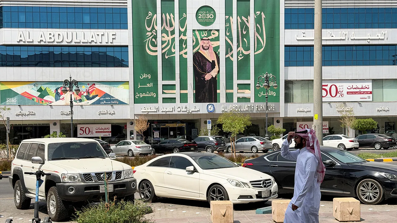 A Saudi man walks past a banner of Saudi Crown Prince Mohammed bin Salman displayed on a commercial building in Riyadh, Saudi Arabia, October 15, 2026. Picture taken with a mobile phone. REUTERS