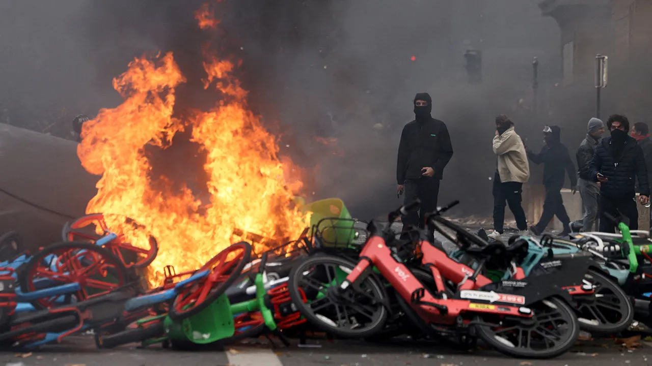 Masked protesters stand next to burning bicycles amid clashes during a demonstration against the cost of living and rising fuel prices near the Place de la Republique in Paris as part of nationwide protests called by the "Yellow Vests" movement, joined by French high school and university students, teachers and parents demanding better school conditions and government action, as well as labour unions, workers, farmers and retirees, France, October 17, 2026. REUTERS/Jack Taylor